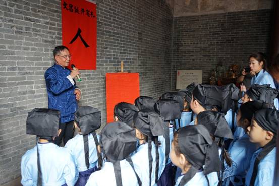 唐观挺在文昌诞带领孩童讲解民俗由来。摄影：甘晓涛